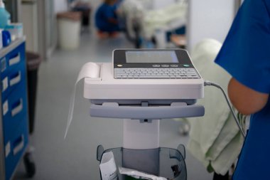 Tıbbi ekipman yakınlardaki bir sağlık uzmanıyla elektrokardiyogram verisi kaydediyor.