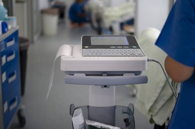 Tıbbi ekipman yakınlardaki bir sağlık uzmanıyla elektrokardiyogram verisi kaydediyor.
