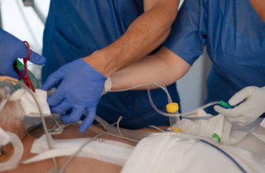 Doktorlar ve hemşireler entübe edilmiş bir hastaya yoğun bakım sağlıyorlar.