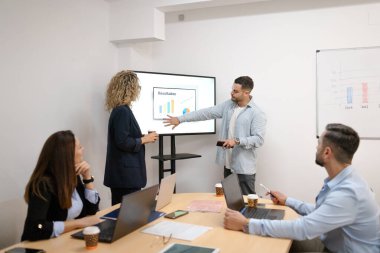 Modern bir ofiste işbirliği yapan ve veri sunan iş adamları