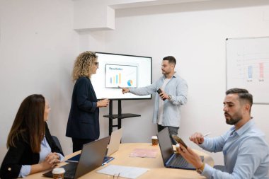 Ofisteki bir kurumsal sunum sırasında veri sonuçları üzerinde işbirliği yapan iş ekibi