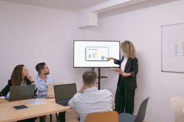 Şirket yönetim kurulunda veri analizi ve finansal çizelge üzerinde işbirliği yapan iş ekibi