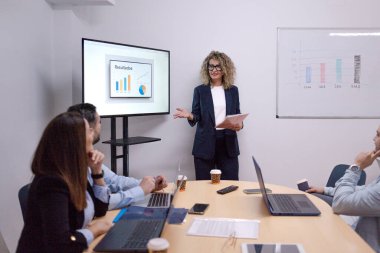 Strateji üzerinde işbirliği yapan iş adamları modern bir konferans salonunda sonuç alıyorlar.