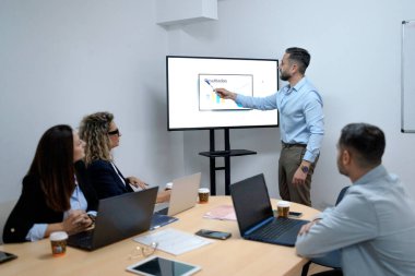 İş adamı, bir ofis toplantısı sırasında iş arkadaşlarına veri sonuçlarını sunuyor