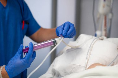 Hastanedeki hastaya sıvı yemek ya da ilaç sağlayan bir tıp uzmanı.