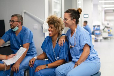 Klinik bir ortamda çalışan ve yoldaşlık anlarını paylaşan çeşitli sağlık uzmanları grubu