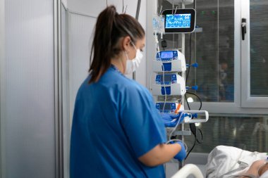 Tıbbi cihazlarla çalışan hemşire, yoğun bakım ünitesinde tedavi görüyor.