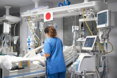 Yoğun bakımdaki hastalarla ilgilenen hemşire.