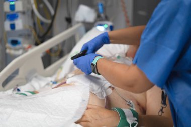 Yoğun bakımda yaşam destek ünitesine bağlı hastaların hayati belirtilerini kontrol eden tıbbi personel.