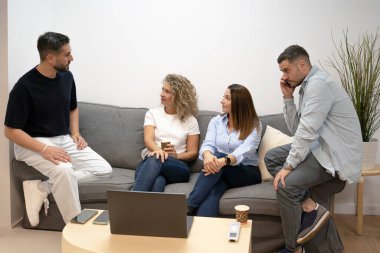 Rahat bir başlangıç ortamında fikirleri tartışan ve iletişim kuran dört profesyonel