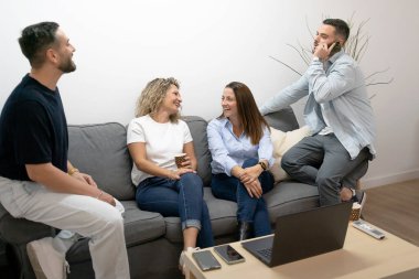 Bir grup meslektaş fikirleri tartışıyor ve sıradan bir ofis ortamında birlikte çalışıyorlar.