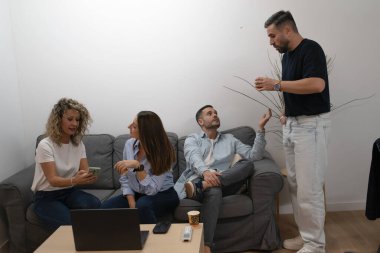 Genç iş arkadaşları modern bir ofiste rahat bir toplantıda işbirliği yapıyorlar.