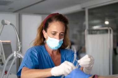 Hemşire tıbbi ekipmanları ayarlıyor ve hastanın damar yolu hastane ortamında.