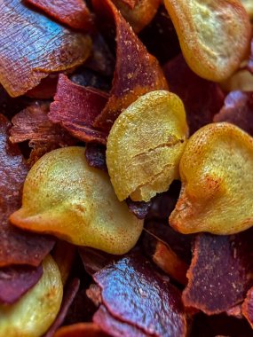 Kırmızı, turuncu ve sarı dokuları gösteren ezilmiş kırmızı biber tanelerinin uç makrosu, baharat, ısı, yemek pişirme ve yemek geçmişi kavramları için idealdir..