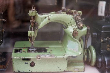 Kırık iğnesi olan yeşil bir dikiş makinesi. Makine eski ve üzerinde çok pas var.