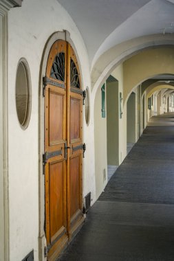 Bern İsviçre 'de, ucunda ahşap bir kapı olan uzun bir koridor. Kapı açık ve koridor boş.