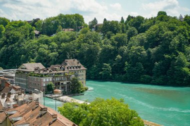 İsviçre 'de içinden bir nehir akan ve üzerinde bir köprü olan bir Bern şehri. Binalar eski ve çok karakterli.