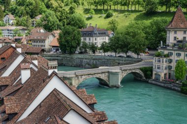 İsviçre 'de içinden bir nehir akan ve üzerinde bir köprü olan bir Bern şehri. Binalar eski ve çok karakterli.
