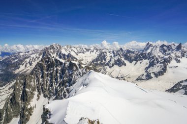 Fransız Alpleri 'ndeki tırtıklı, yüksek, karla kaplı dağların manzarası. Fotoğraf Aiguille du Midi dağından çekildi. Chamonix. Ayak izleriyle kaplı büyük kar görülebilir.