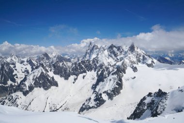 Fransız Alpleri 'ndeki tırtıklı, yüksek, karla kaplı dağların manzarası. Fotoğraf Aiguille du Midi dağından çekildi. Chamonix. Ayak izleriyle kaplı büyük kar görülebilir.