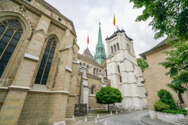 Cenevre 'de saat kulesi ve yeşil kulesi olan büyük beyaz bir bina. Bina tuğla bir geçitle çevrili.