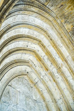 Görüntü, eğri bir tasarımı olan taş bir duvarın görüntüsü. Duvar taştan yapılmış ve benzersiz, karmaşık bir deseni var. Sahne zarafet ve entelektüelliktir, eğri dizayn gibi.