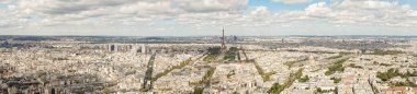 Fransa 'nın Paris şehrinin panoramik manzarası Montparnasse gökdeleninin tepesinden çekildi. Eyfel Kulesi ve diğer birçok simge görülebilir. Gökyüzü mavi ve bulutlu.