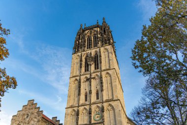 Kule binası Almanya 'nın Munster şehrinin sokaklarındaki Gotik bir dekorasyondur. Gökyüzü mavi ve berrak. Liebfrauen Uberwasserkirche