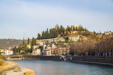 İtalya 'nın Verona kentindeki Adige Nehri' nin setinden şehrin yüksek kesimine doğru bakın. Köprü ve tepenin üzerindeki şehir görülebilir..