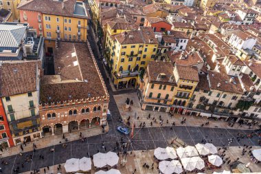 İtalya 'nın Verona şehrinin merkezinde saat kulesi var. Şehir insan ve binalarla dolu..