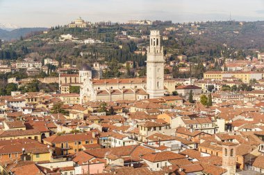 Uzaktan Verona, İtalya 'nın panoramik manzarası katedral kompleksinin yukarısından görülebilir. Karla kaplı Alp dağları ve mavi gökyüzü görülebilir. Birçok kırmızı kiremitli çatı da görülebilir.