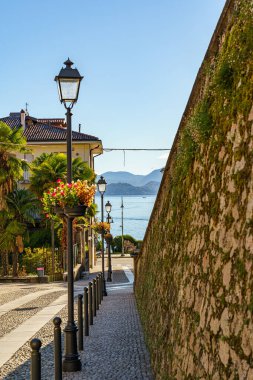 İtalya 'nın Maggiore Gölü' ndeki Baveno kasabasında eski ve rahat bir cadde. Arka planda dağların silueti ve Lago Maggiore Gölü görülebilir..