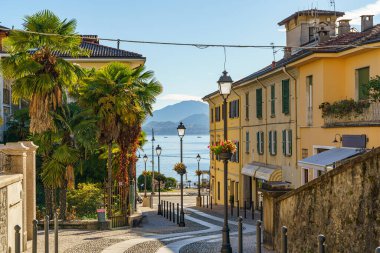 İtalya 'nın Maggiore Gölü' ndeki Baveno kasabasında eski ve rahat bir cadde. Arka planda dağların silueti ve Lago Maggiore Gölü görülebilir..