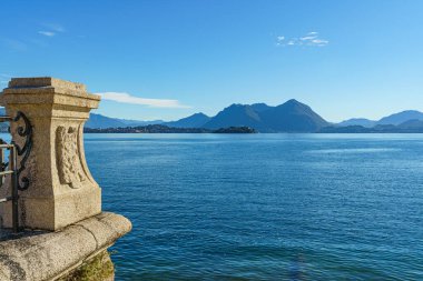İtalya 'da Maggiore Gölü' nün çok güzel bir manzarası ve denizde bir teknesi var. Gökyüzü açık ve güneş parlıyor..