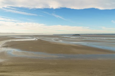 Atlantik Okyanusu 'nda, Normandiya, Fransa' daki Mont Saint-Michel 'in kale duvarlarından çekilen muhteşem bir gelgit. Fotoğraf akşam çekildi ve su neredeyse görünmezdir..