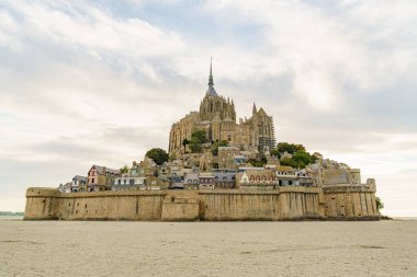Normandiya, Fransa 'daki Mont Saint Michel Manastırı, öğleden sonra erken saatlerde fotoğraflandı. Gökyüzü mavi ve bulutlu. Kalenin yakınında kimse yok. Fotoğraf gelgit sırasında çekildi..