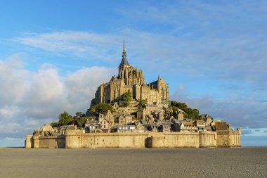 Normandiya, Fransa 'daki Mont Saint Michel Manastırı, öğleden sonra erken saatlerde fotoğraflandı. Gökyüzü mavi ve bulutlu. Kalenin yakınında kimse yok. Fotoğraf sabah çekildi..