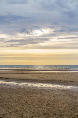 Deauville, Normandiya, Fransa 'da gün batımında terk edilmiş okyanus plajı..
