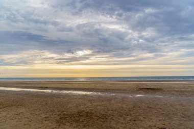 Deauville, Normandiya, Fransa 'da gün batımında terk edilmiş okyanus plajı..