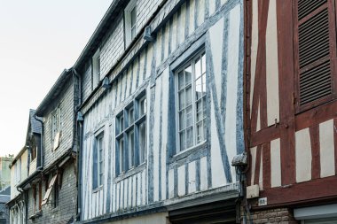 Normandiya, Fransa 'da mavi ve kahverengi kirişli eski bir ahşap binanın cephesi.