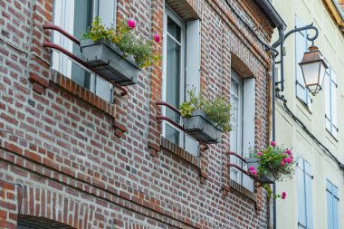 Binanın Fransa 'da içinde çiçekler olan üç pencere kutusu var. Kutular binanın pencerelerine yerleştiriliyor ve tuğla dış yüzeyine biraz renk ve yaşam katıyor..