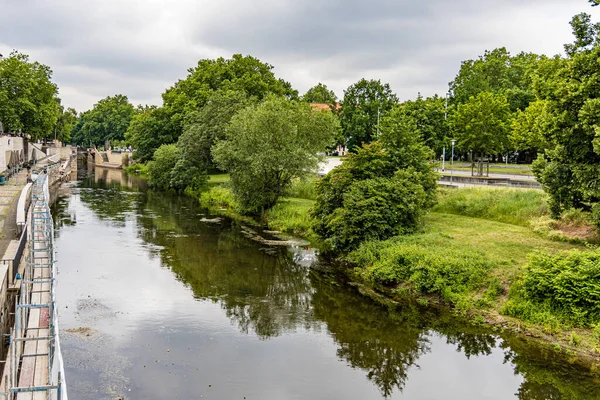 Hanover Almanya 'sında köprüsü ve ağaçları olan bir nehir. Su sakin, ağaçlar yeşil..