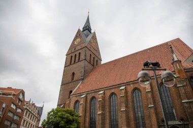 Hanover, Almanya 'da kırmızı tuğlalı bir Katolik kilisesi. Fotoğraf bulutlu bir günde aşağıdan çekildi..