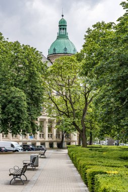 Binanın tepesinde büyük yeşil bir kubbe olan bir park. Hanover Almanya 'sındaki parkta banklar ve ağaçlar var..