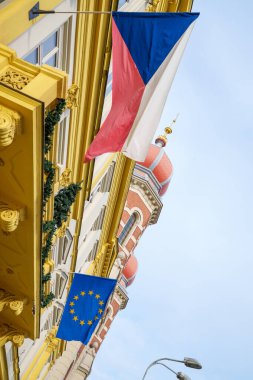 Ön cepheli binada, üzerinde Çek Cumhuriyeti bayrağı ve Avrupa Birliği 'nin frak mantosunun asılı olduğu oymalı bir kabartma yer alıyor..