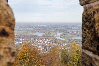 Büyük Wilhelm anıtından Almanya 'nın Port Westphalia kentinin manzarası. Ufukta bulutlu bir gökyüzü, akşam ve puslu tepeler var..