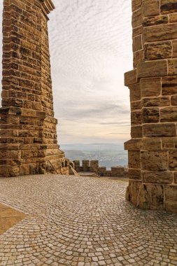 Büyük Wilhelm anıtından Almanya 'nın Port Westphalia kentinin manzarası. Ufukta bulutlu bir gökyüzü, akşam ve puslu tepeler var..