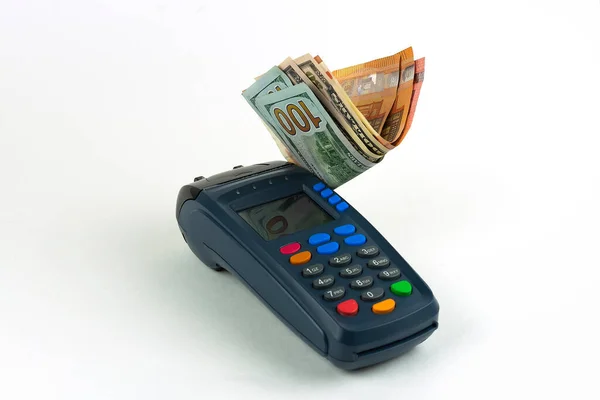 Koyu mavi ödeme terminali. Beyaz arka planda çok renkli raptiyeler var. Dolar ve euro banknotları. Ön görünüm