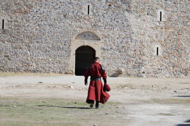 A man in historical costume against the backdrop of a fortress. High quality photo