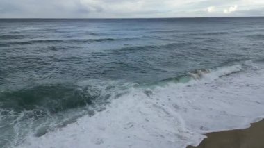 Dalgalar sahile çarpıyor. Okyanus dalgaları kıyı şeridi. Turkuaz kıyı şeridi. Yüksek kalite 4k görüntü